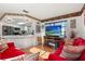 Inviting living space with red sofas, wooden TV stand, bright lighting, connected to kitchen counter at 8215 Hixton Dr, Port Richey, FL 34668