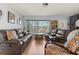 Living room with wood floors, leather reclining sofas, and a view of the front yard at 8215 Hixton Dr, Port Richey, FL 34668