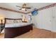 Comfortable main bedroom with a ceiling fan, TV, wood floors, and access to an ensuite bathroom at 8215 Hixton Dr, Port Richey, FL 34668