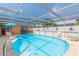 A bright blue pool is enclosed in a screened patio with a view of the landscaped yard at 8215 Hixton Dr, Port Richey, FL 34668