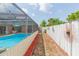 Screened-in pool area with a pathway next to a decorative fence, perfect for relaxation at 8215 Hixton Dr, Port Richey, FL 34668