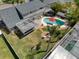 Aerial view of backyard with pool, tiki bar, fenced yard, covered patio, and seating area at 8326 Archwood Cir, Tampa, FL 33615