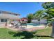 A backyard oasis featuring a pool, tiki bar, and lounge furniture creating an ideal outdoor entertaining space at 8326 Archwood Cir, Tampa, FL 33615