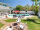 Backyard featuring a fire pit and pool area with tropical landscaping and tiki bar at 8326 Archwood Cir, Tampa, FL 33615