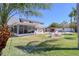 Manicured backyard with an outdoor seating area with a fire pit, tiki bar, and pool at 8326 Archwood Cir, Tampa, FL 33615