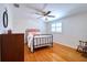 Bedroom featuring hardwood floors, ceiling fan, shutters, and charming decor at 8326 Archwood Cir, Tampa, FL 33615