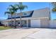 Two-story home with a neutral color palette, attached two car garage, and a well manicured front yard at 8326 Archwood Cir, Tampa, FL 33615