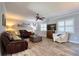 Bright living room featuring a sectional, a ceiling fan, plantation shutters on the windows, and views of the neighborhood at 8326 Archwood Cir, Tampa, FL 33615