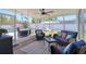 Screened-in porch with comfortable wicker seating and ceiling fan overlooking the backyard at 8326 Archwood Cir, Tampa, FL 33615