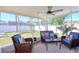 Screened-in porch with comfortable wicker seating and ceiling fan overlooking the backyard at 8326 Archwood Cir, Tampa, FL 33615