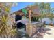 Outdoor tiki bar is fully equipped with bar seating, grill, and countertop prep space in a tropical backyard setting at 8326 Archwood Cir, Tampa, FL 33615