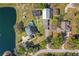 Property aerial view featuring home, pool, outbuilding, and large pond, offering privacy and space at 8403 Southwood Pines St, Lithia, FL 33547