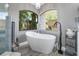 Bathroom features soaking tub with modern fixtures under large arched windows at 8403 Southwood Pines St, Lithia, FL 33547