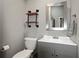 Bathroom with grey vanity, modern mirror and decorative shelving at 8403 Southwood Pines St, Lithia, FL 33547