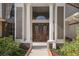 Elegant front entrance with stately columns, decorative double doors, and manicured landscaping at 8403 Southwood Pines St, Lithia, FL 33547