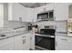 Stainless steel appliances in kitchen with white cabinets and tile backsplash at 8403 Southwood Pines St, Lithia, FL 33547