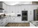 Bright kitchen features white cabinets, subway tile backsplash, stainless appliances, and granite countertops at 8403 Southwood Pines St, Lithia, FL 33547