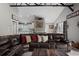 Inviting living room featuring a large leather sectional couch, beam ceiling and open concept to kitchen at 8403 Southwood Pines St, Lithia, FL 33547