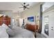 Bedroom with vaulted ceilings, ceiling fan, television and ensuite bath in neutral tones at 8403 Southwood Pines St, Lithia, FL 33547