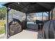 Covered outdoor dining area featuring a grill, a table with seating, and outdoor storage at 8403 Southwood Pines St, Lithia, FL 33547