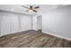 Empty bedroom features wood-look flooring, a ceiling fan, and two closets at 9105 W Hillsborough Ave # I102, Tampa, FL 33615