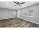 Bedroom with stylish flooring, ceiling fan, mirror, and window view of outdoors at 9105 W Hillsborough Ave # I102, Tampa, FL 33615