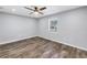 Empty bedroom features wood-look flooring, a ceiling fan, and a window at 9105 W Hillsborough Ave # I102, Tampa, FL 33615