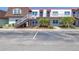 Two-story condo building featuring stair access, palm trees, and parking spots at 9105 W Hillsborough Ave # I102, Tampa, FL 33615