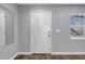 Bright entryway featuring a white door, wood-look flooring, and window with blinds at 9105 W Hillsborough Ave # I102, Tampa, FL 33615