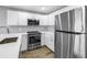 Bright, modern kitchen featuring stainless steel appliances, white cabinets, and plenty of counter space at 9105 W Hillsborough Ave # I102, Tampa, FL 33615