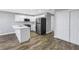 Updated kitchen with stainless steel appliances, white cabinets, quartz countertops, and wood look flooring at 9105 W Hillsborough Ave # I102, Tampa, FL 33615