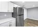 Modern kitchen features stainless steel appliances, white cabinets, quartz countertops, and wood look flooring at 9105 W Hillsborough Ave # I102, Tampa, FL 33615