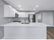 Bright kitchen features stainless steel appliances, white cabinets, quartz countertops, and a stylish island at 9105 W Hillsborough Ave # I102, Tampa, FL 33615