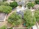An aerial view of a dark-roofed house surrounded by lush greenery, with a playground in the backyard at 934 Grand Canyon Dr, Valrico, FL 33594