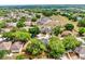An aerial view of a neighborhood with many houses, trees, and a pond in the background at 934 Grand Canyon Dr, Valrico, FL 33594