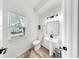The powder room features white walls, a pedestal sink, and wood-look flooring at 934 Grand Canyon Dr, Valrico, FL 33594