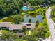 Aerial view of a community with lush landscaping, a pond, and a swimming pool at 10 James Ct, Oldsmar, FL 34677
