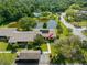 An aerial view of a landscaped community with a pond and mature trees at 10 James Ct, Oldsmar, FL 34677