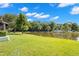 Lush green backyard extending to a tranquil pond, perfect for relaxation and enjoying nature at 10 James Ct, Oldsmar, FL 34677