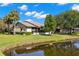 Rear exterior view showcasing a well-maintained lawn gently sloping to a calm pond at 10 James Ct, Oldsmar, FL 34677