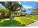 Inviting single-story home with lush green lawn, mature trees, and a walkway to the front door at 10 James Ct, Oldsmar, FL 34677