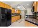 Functional kitchen with tiled flooring, featuring black appliances and ample cabinet space at 10 James Ct, Oldsmar, FL 34677