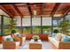 Cozy sunroom with wood paneling, a beamed ceiling, wicker furniture, and large windows offering water views at 10 James Ct, Oldsmar, FL 34677