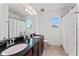 Bathroom with granite countertops, dual sinks, large mirror, and shower with curtain at 10007 Hazelnut Ct, Tampa, FL 33647