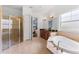 Primary bathroom featuring a large tub, separate shower, and tiled floors at 10007 Hazelnut Ct, Tampa, FL 33647