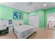 Bright bedroom featuring light green walls, a white bed with white headboard, and a matching white desk at 10007 Hazelnut Ct, Tampa, FL 33647