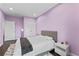 Bedroom with lilac colored walls, hardwood floors, a window with natural light, and a modern bed at 10007 Hazelnut Ct, Tampa, FL 33647