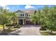 Beautiful two-story home featuring a three-car garage, well-manicured lawn, and mature trees at 10007 Hazelnut Ct, Tampa, FL 33647