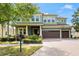 Beautiful two-story home featuring a three-car garage, well-manicured lawn, and lush landscaping at 10007 Hazelnut Ct, Tampa, FL 33647