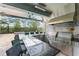 Outdoor kitchen features stainless steel BBQ, a bar counter, and decorative tile at 10007 Hazelnut Ct, Tampa, FL 33647